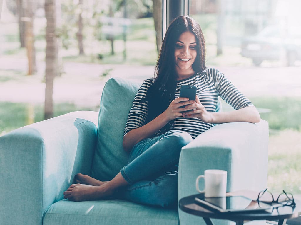 Woman relaxing on chair using smartphone
