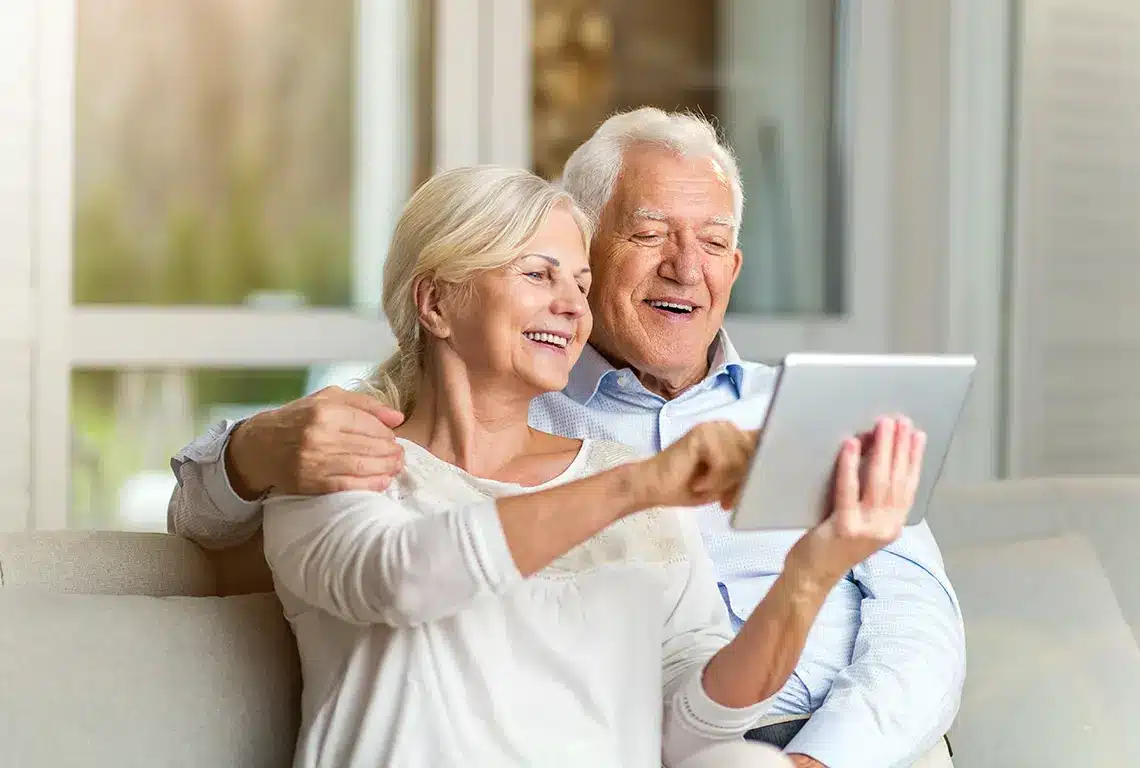 Smiling seniors using a digital tablet together