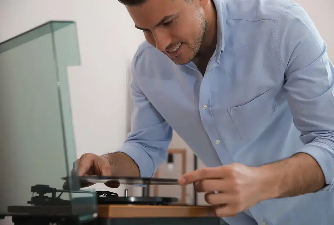 Man placing vinyl record on turntable