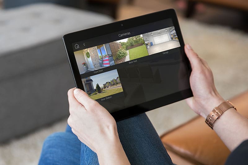 Person viewing home security cameras on tablet