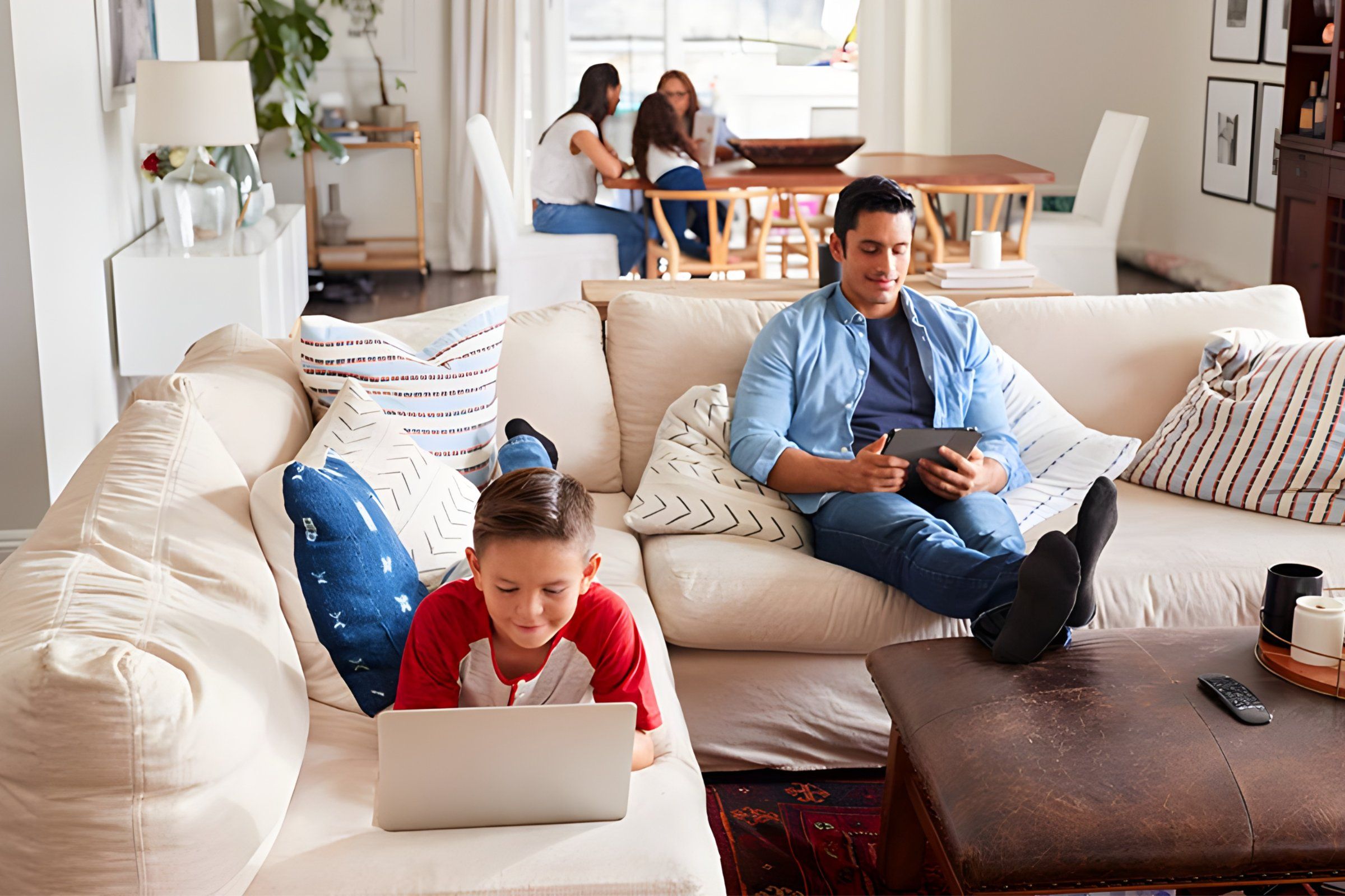 Family using laptops and tablets in living room