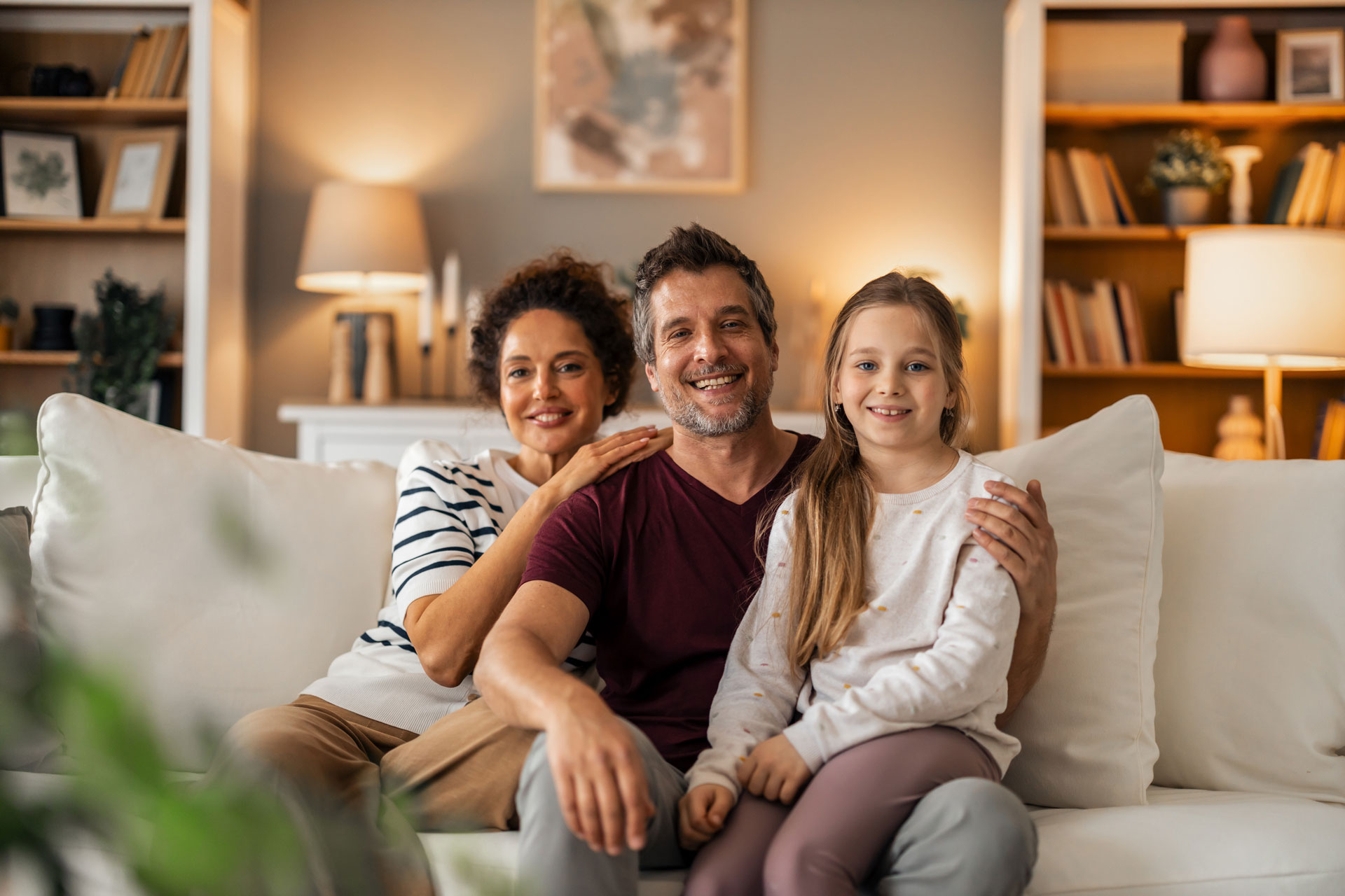 Happy family sitting together on living room sofa