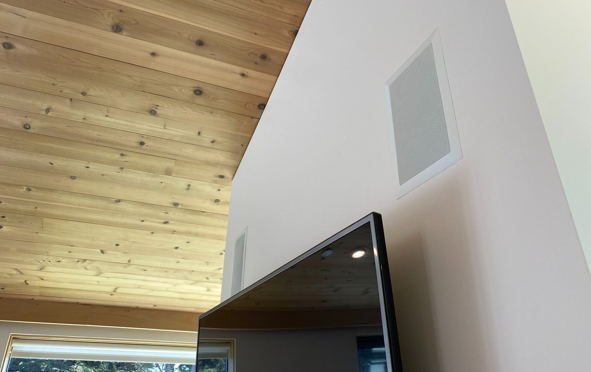 Wall speakers above modern flat screen TV